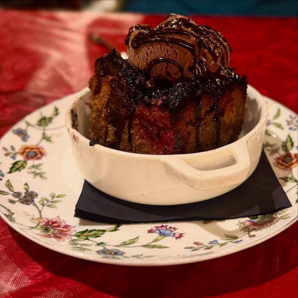 Harvey's chocolate bread pudding with chocolate ice cream and drizzle, served on a floral plate.
